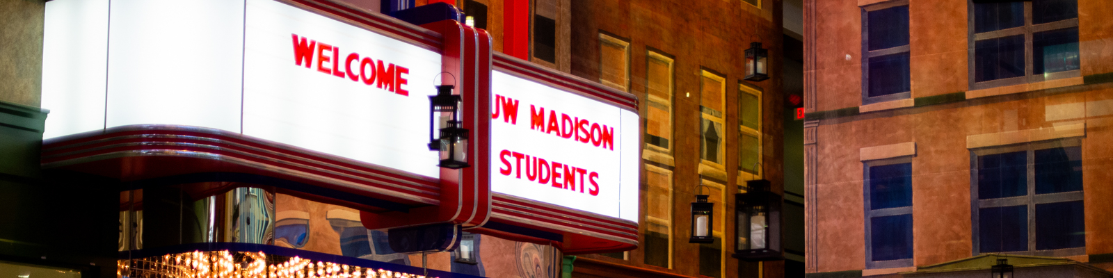 UW Madison students at an internship opportunity with a sign that says Welcome UW Madison Students in the background